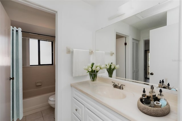 full bathroom with tile patterned flooring, vanity, tiled shower / bath, and toilet