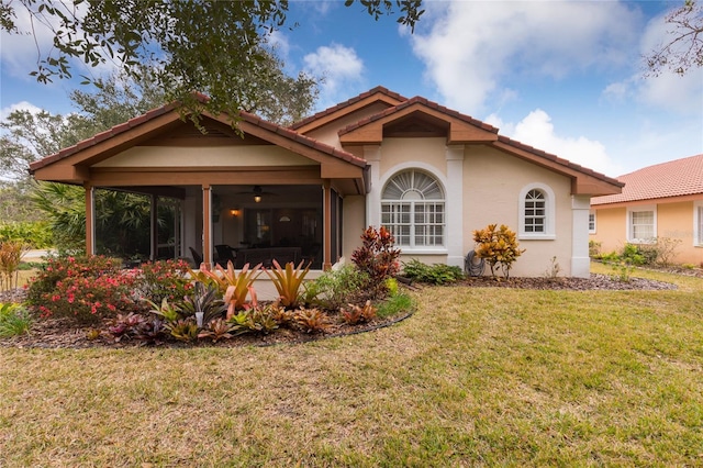 rear view of house with a yard and ceiling fan