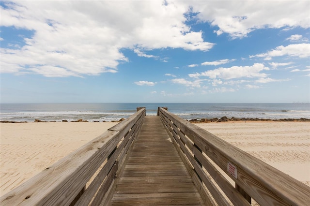 view of community featuring a water view and a beach view