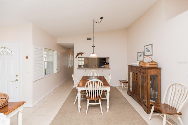 dining area featuring vaulted ceiling and light tile patterned floors