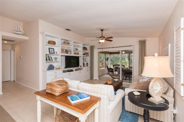 living room featuring vaulted ceiling, light tile patterned floors, ceiling fan, and a textured ceiling