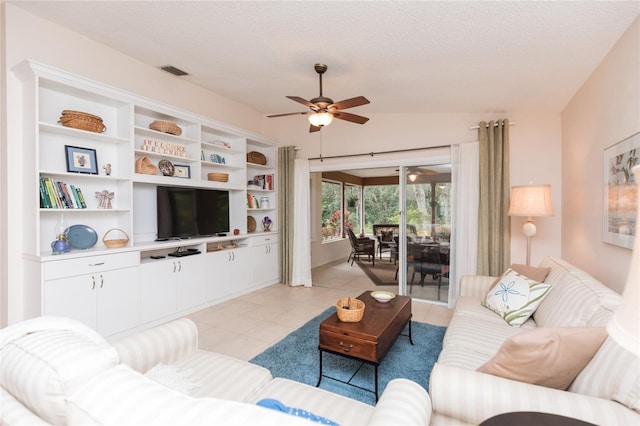 living room with light tile patterned flooring, ceiling fan, lofted ceiling, and a textured ceiling