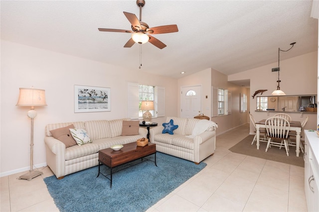 living room featuring light tile patterned floors, vaulted ceiling, and plenty of natural light