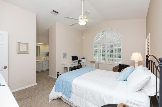 carpeted bedroom featuring ceiling fan, lofted ceiling, and ensuite bathroom