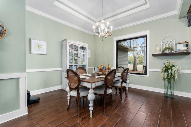 dining room with a raised ceiling, crown molding, and dark wood-type flooring