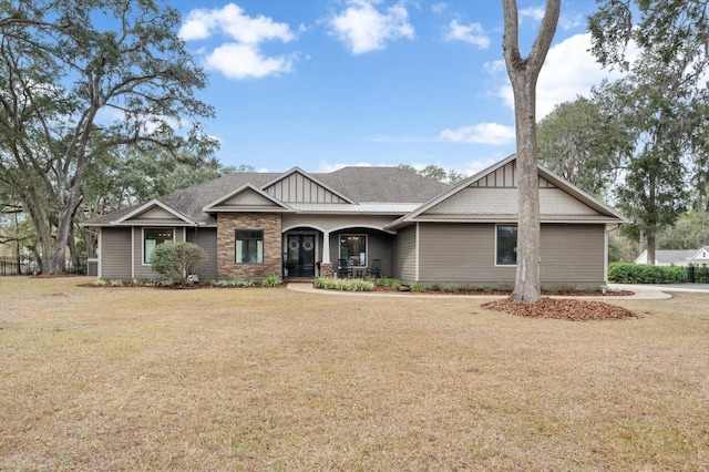 craftsman-style house featuring covered porch and a front lawn