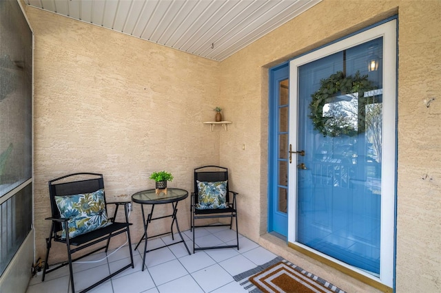 doorway to property featuring a patio area and stucco siding