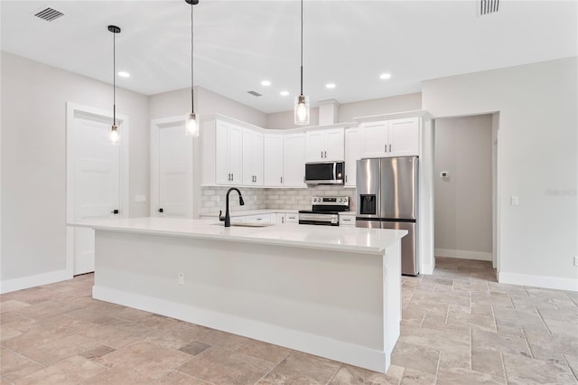 kitchen with sink, white cabinetry, hanging light fixtures, appliances with stainless steel finishes, and an island with sink