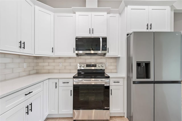 kitchen with white cabinetry, appliances with stainless steel finishes, and backsplash