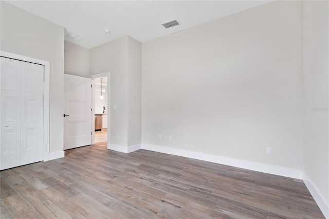 unfurnished bedroom with a closet and light hardwood / wood-style flooring