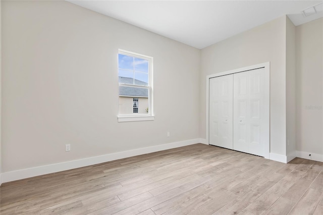 unfurnished bedroom featuring a closet and light hardwood / wood-style flooring