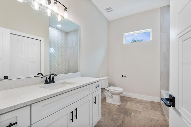 bathroom with vanity, toilet, and tiled shower