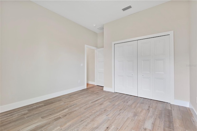 unfurnished bedroom with a closet and light wood-type flooring