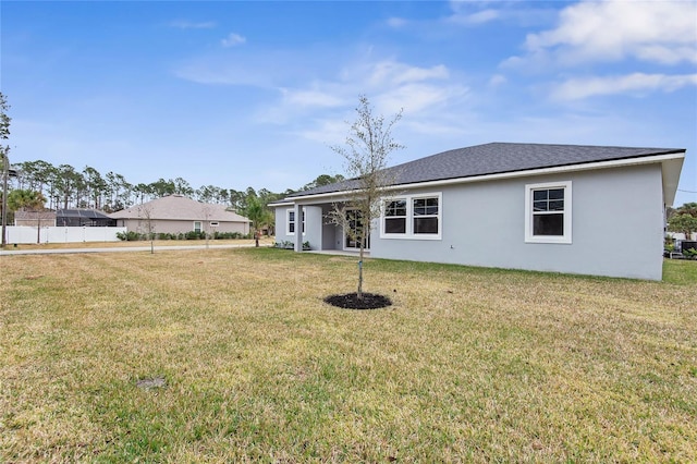 back of property featuring a lawn