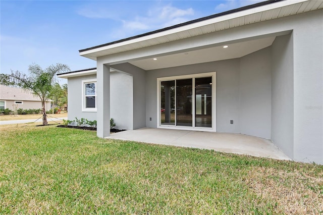 back of property with a yard and a patio area