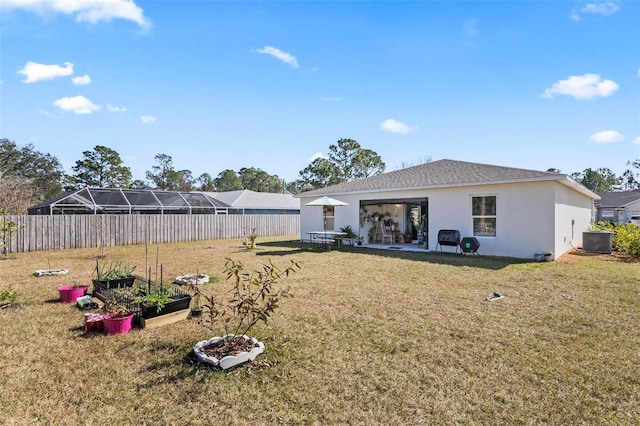 rear view of property with central AC unit and a lawn