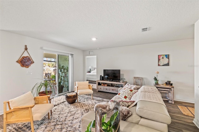 living room with a textured ceiling and dark hardwood / wood-style flooring