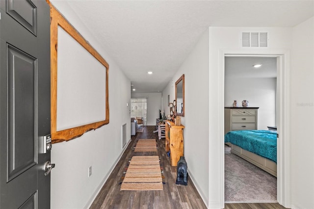 hall featuring dark hardwood / wood-style flooring and a textured ceiling