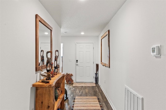 hall with dark wood-type flooring and a textured ceiling