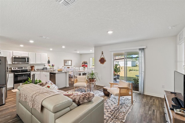 living room featuring a textured ceiling and dark hardwood / wood-style flooring