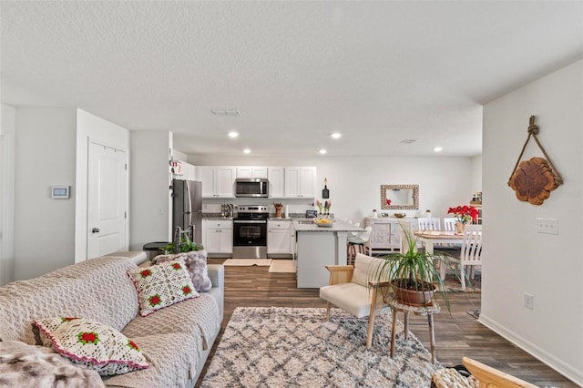 living room with dark hardwood / wood-style floors and a textured ceiling