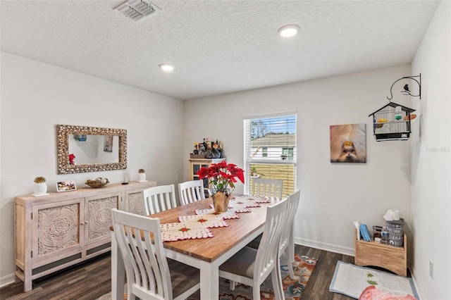 dining area featuring a textured ceiling and dark hardwood / wood-style flooring