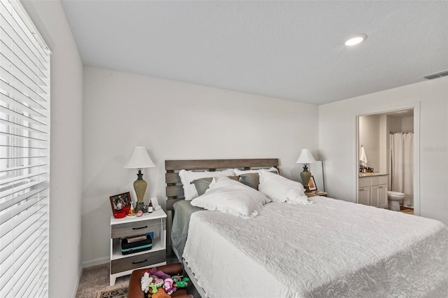 bedroom with carpet floors and ensuite bathroom