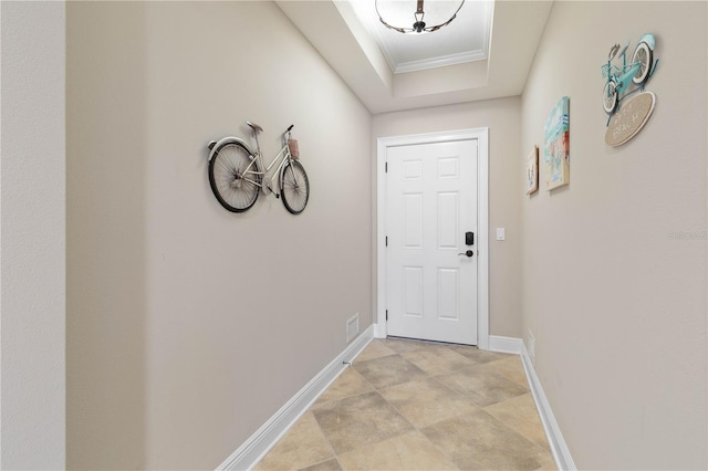 doorway featuring ornamental molding and a tray ceiling