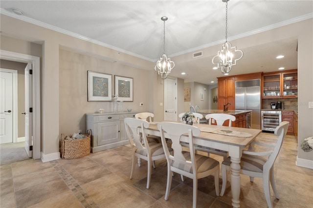 dining space with ornamental molding, beverage cooler, and sink