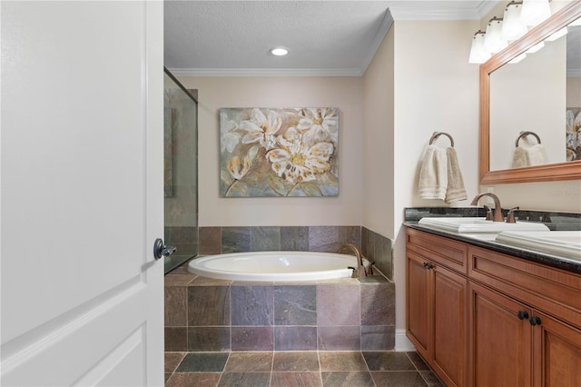 bathroom with crown molding, tiled bath, vanity, and a textured ceiling