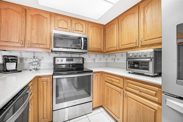 kitchen featuring stainless steel appliances and light tile patterned flooring