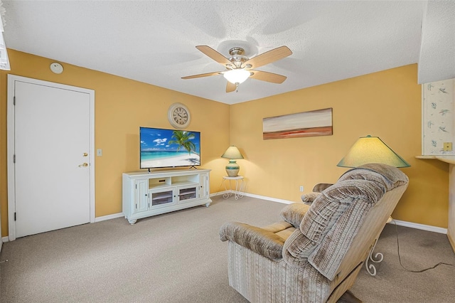 carpeted living room featuring ceiling fan and a textured ceiling