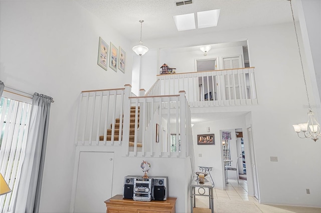 stairs with tile patterned floors, a textured ceiling, and a high ceiling