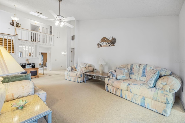 living room featuring a textured ceiling, carpet floors, high vaulted ceiling, and ceiling fan