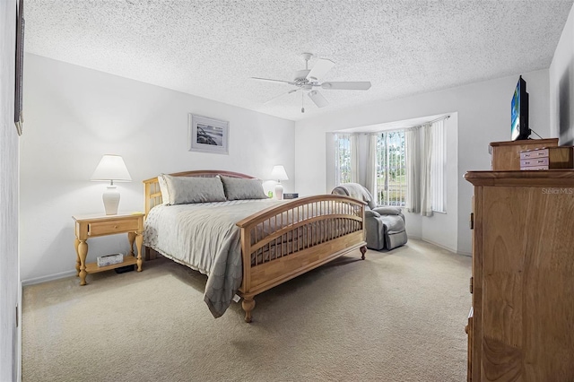 carpeted bedroom featuring ceiling fan and a textured ceiling