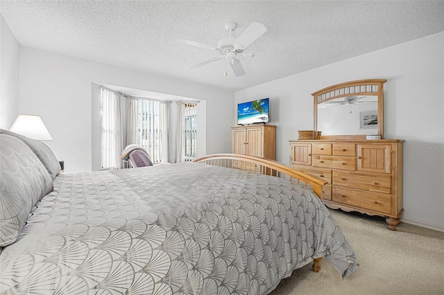 bedroom featuring ceiling fan, light colored carpet, and a textured ceiling