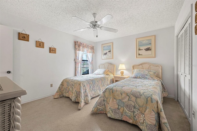 carpeted bedroom featuring ceiling fan, a closet, and a textured ceiling