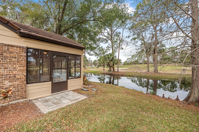 view of yard featuring a water view and a sunroom