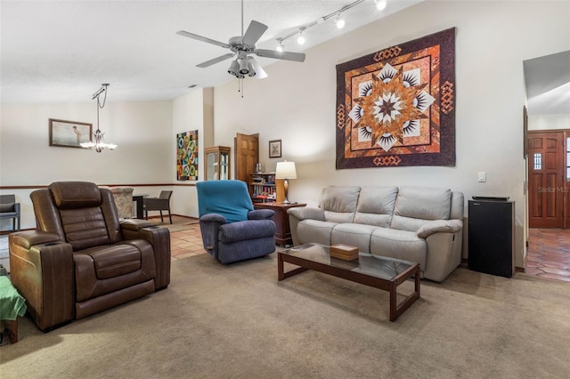 carpeted living room with vaulted ceiling, ceiling fan with notable chandelier, and track lighting