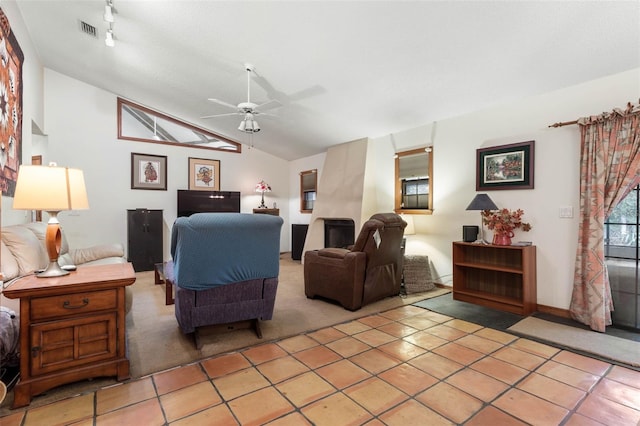 living room featuring lofted ceiling, light tile patterned floors, and ceiling fan