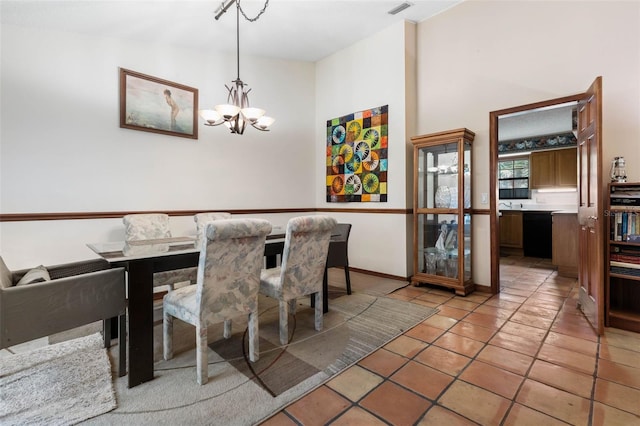 tiled dining room with a chandelier