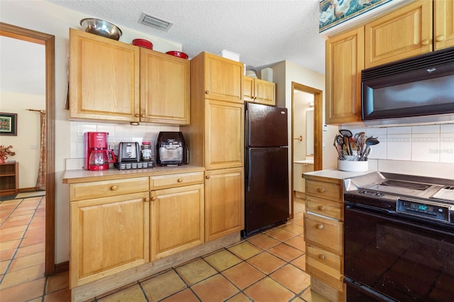 kitchen featuring light tile patterned floors, tasteful backsplash, black appliances, a textured ceiling, and light brown cabinetry