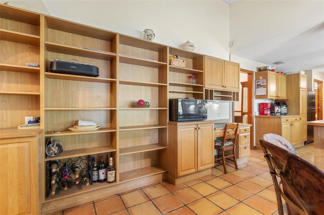 kitchen with a textured ceiling and light tile patterned floors