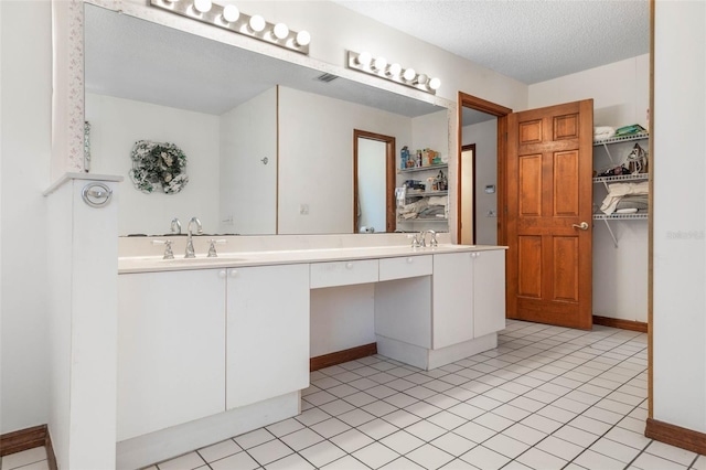 bathroom featuring vanity, tile patterned floors, and a textured ceiling