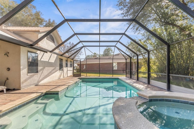 view of pool featuring an in ground hot tub, a patio, and glass enclosure