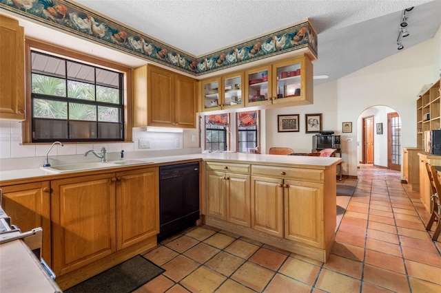 kitchen with black dishwasher, sink, light tile patterned floors, kitchen peninsula, and a textured ceiling