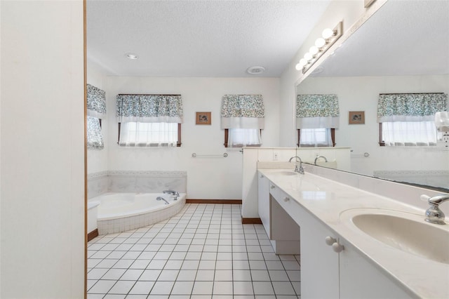 bathroom featuring vanity, a relaxing tiled tub, tile patterned floors, and a textured ceiling