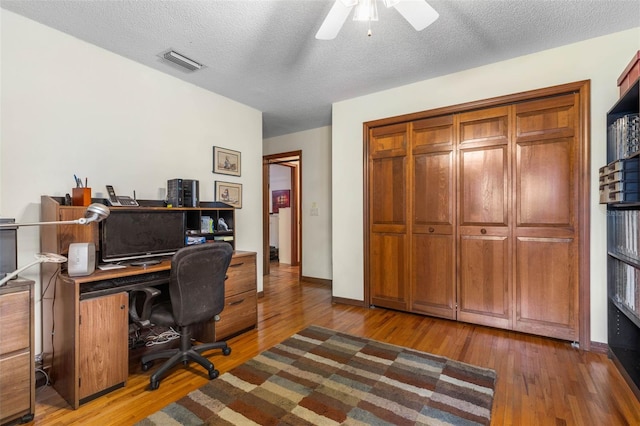 office area featuring ceiling fan, hardwood / wood-style flooring, and a textured ceiling