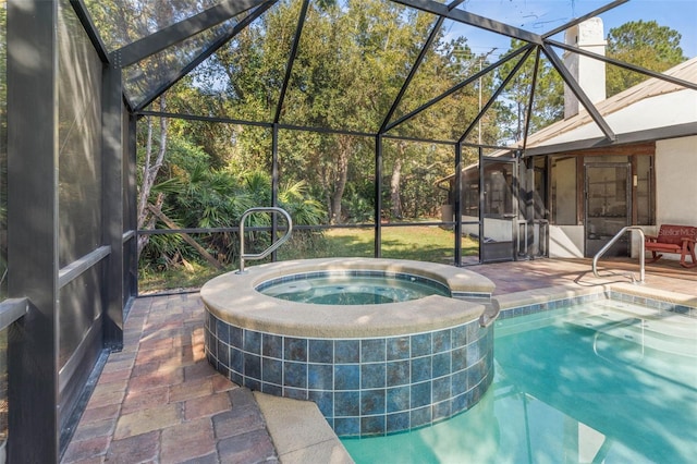 view of swimming pool with an in ground hot tub, a lanai, and a patio area