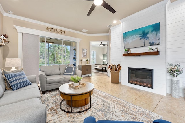 living room with light tile patterned floors, a fireplace, ornamental molding, and ceiling fan